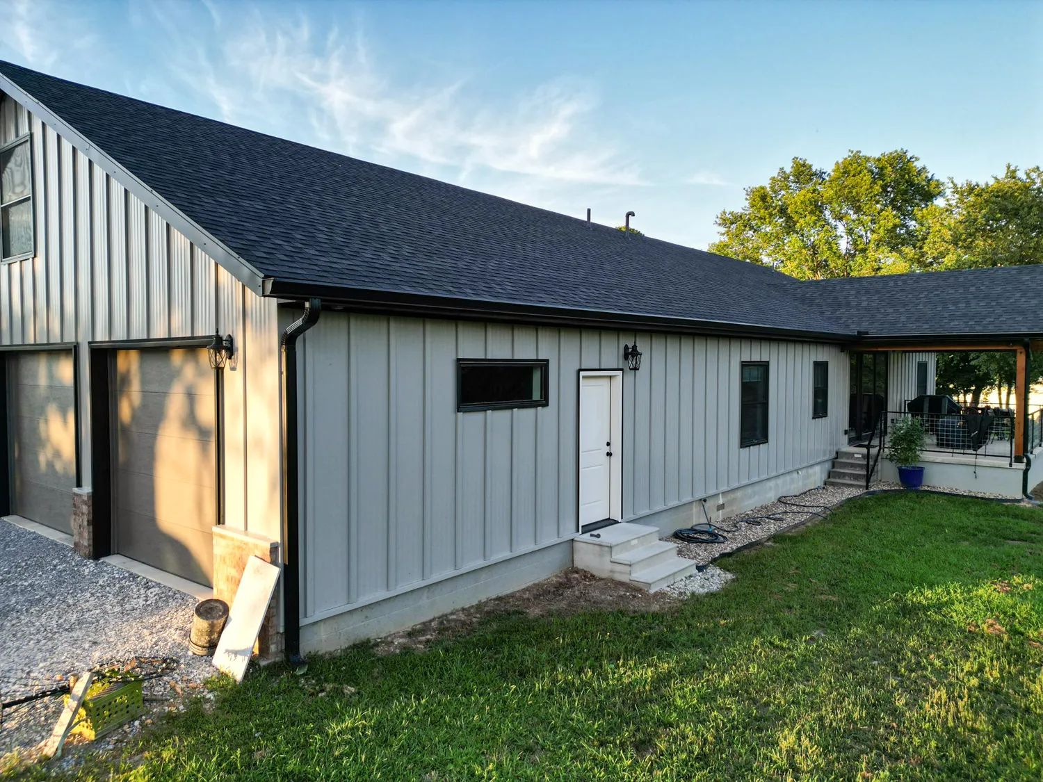 black standing seam metal roof in fayetteville arkansas with a rock chimney