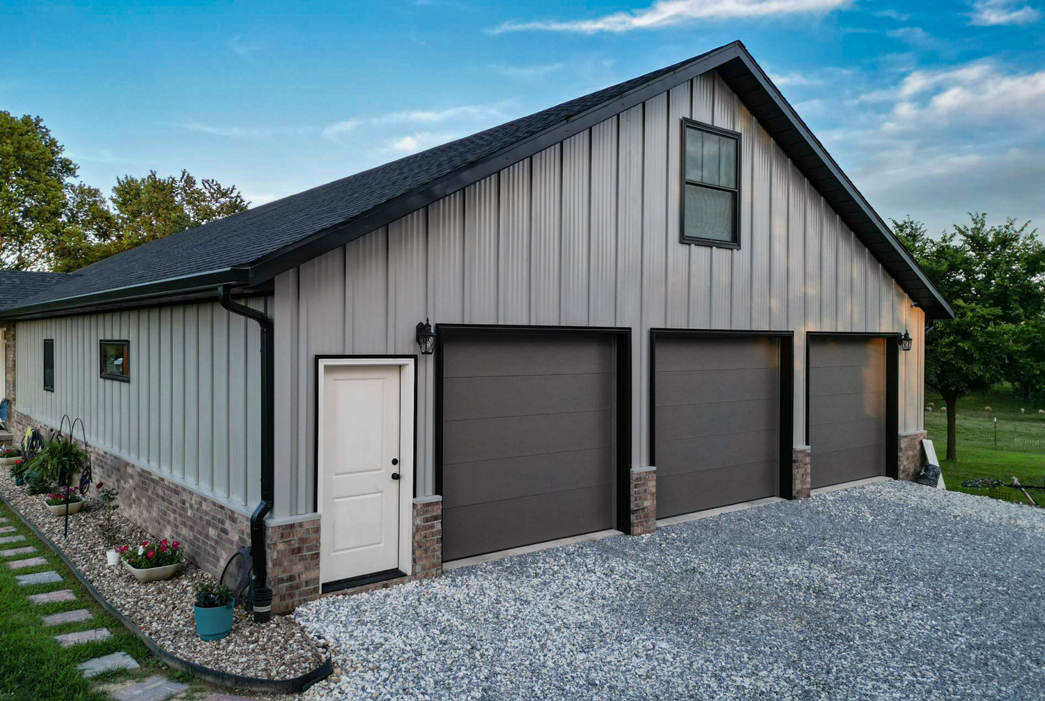 black standing seam metal roof in fayetteville arkansas with a rock chimney