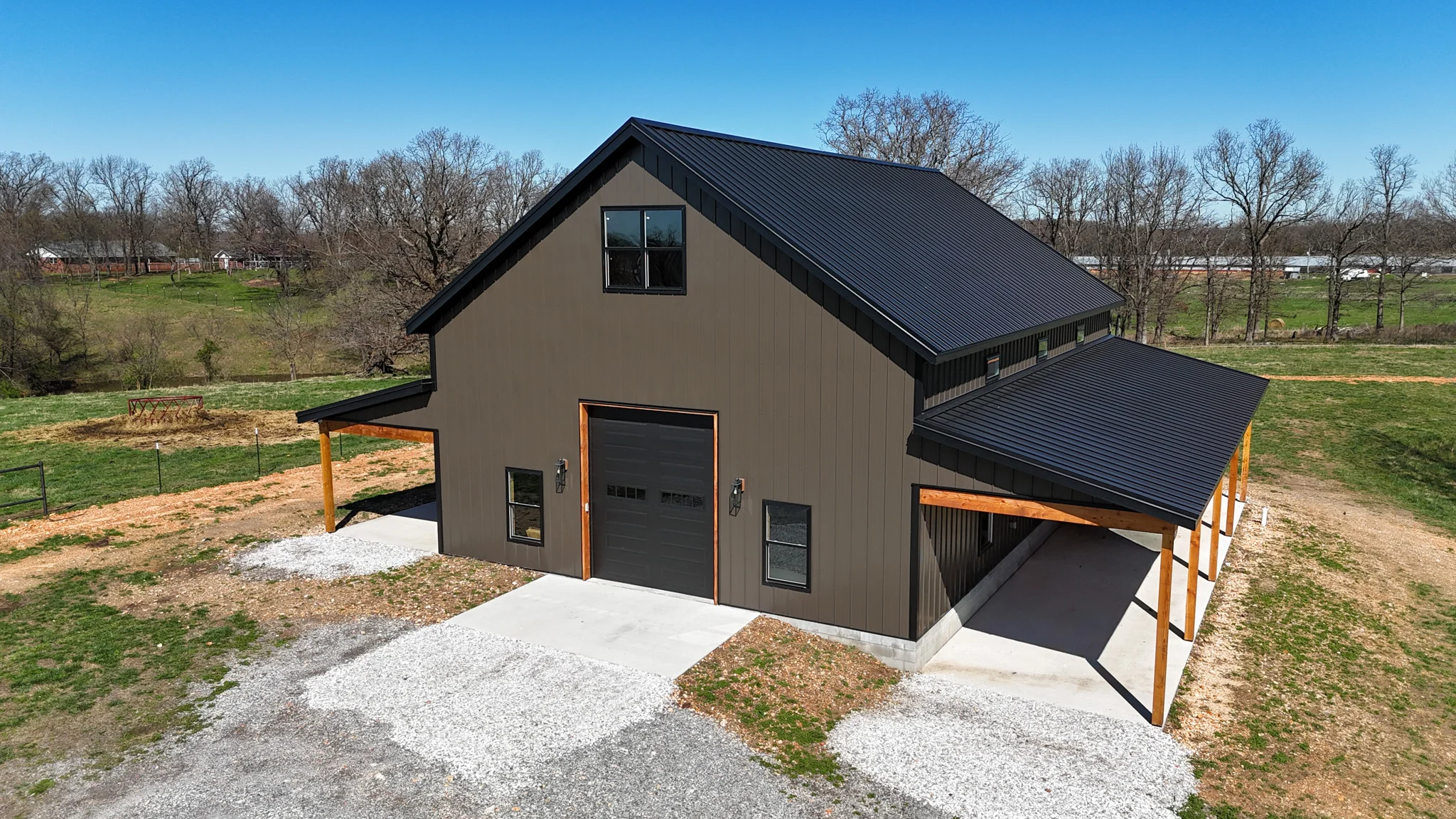 a barndominium in northwest arkansas with metal siding and a black metal roof.