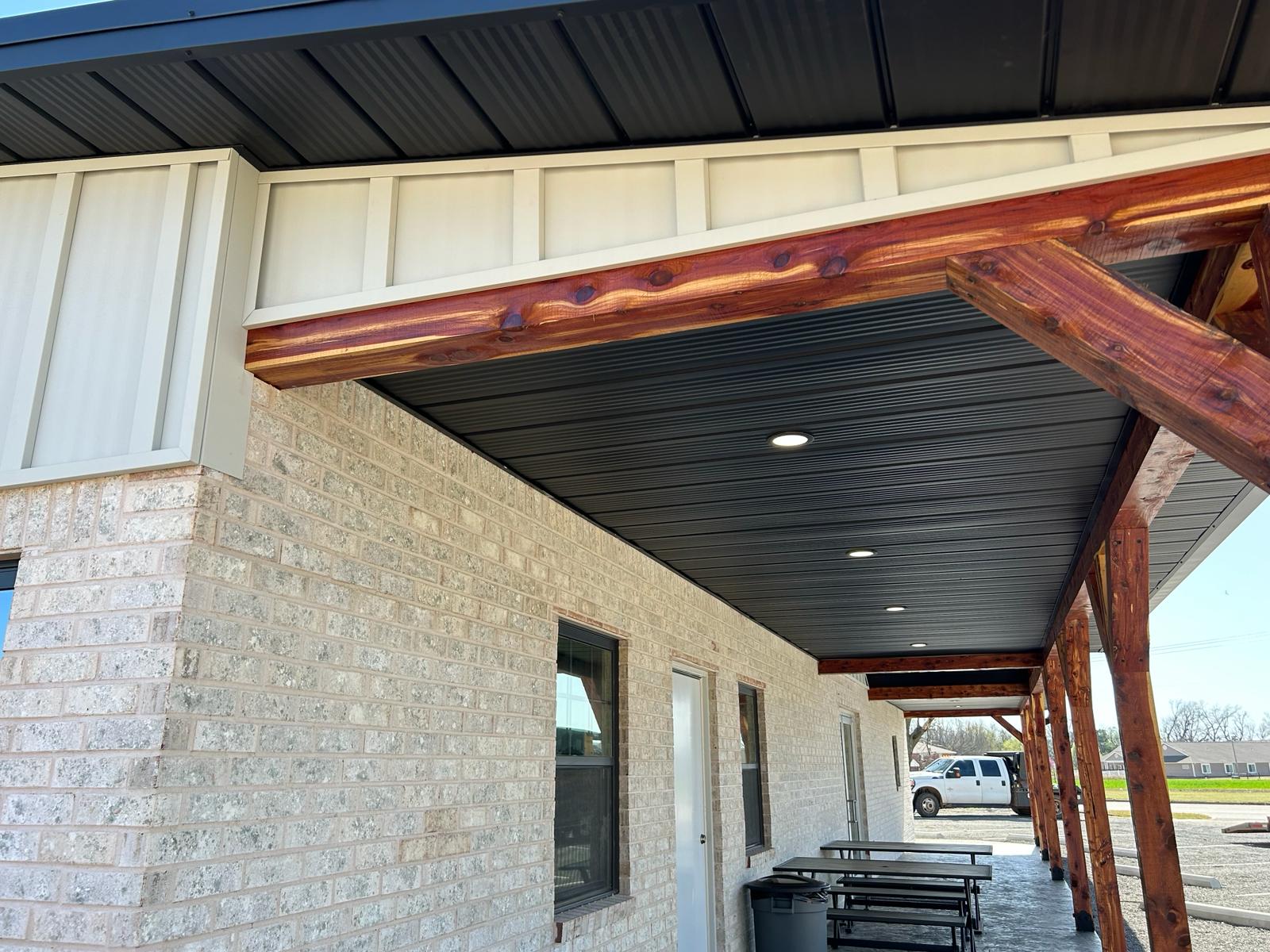 black standing seam metal roof in fayetteville arkansas with a rock chimney