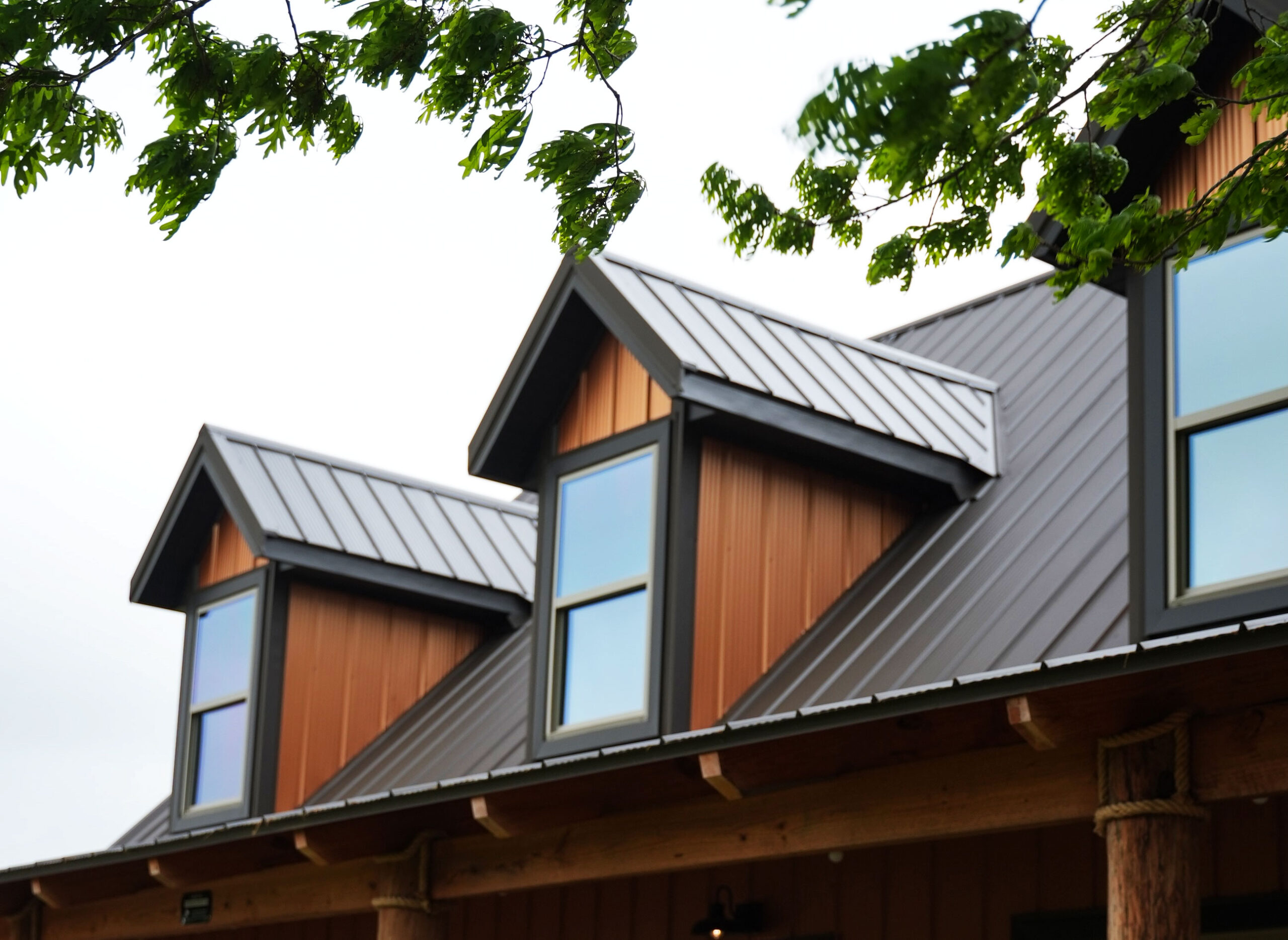 Close up view of roof with signature wave metal panels and dormers highlighting the copper colored metal siding
