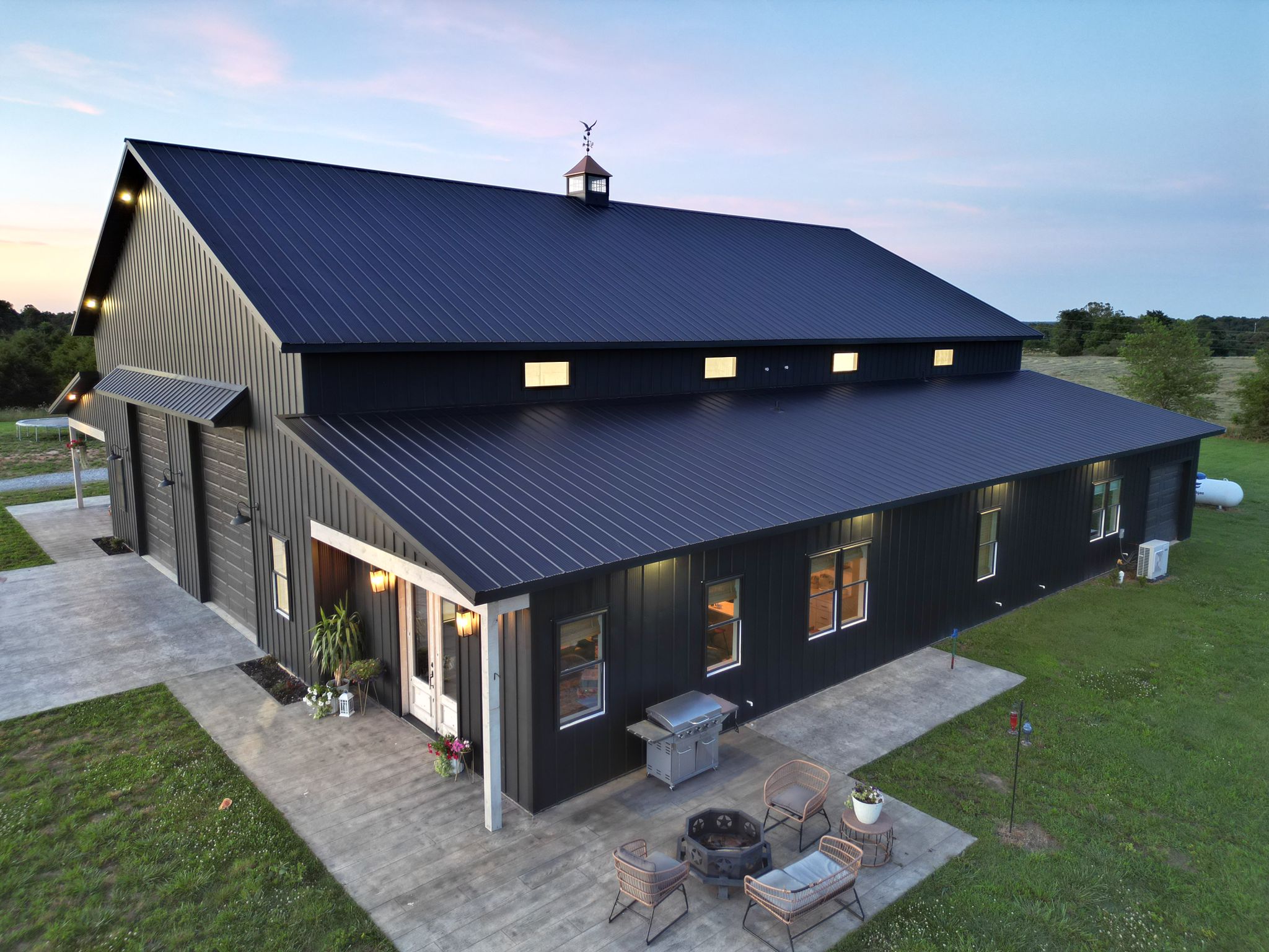 black standing seam metal roof in fayetteville arkansas with a rock chimney
