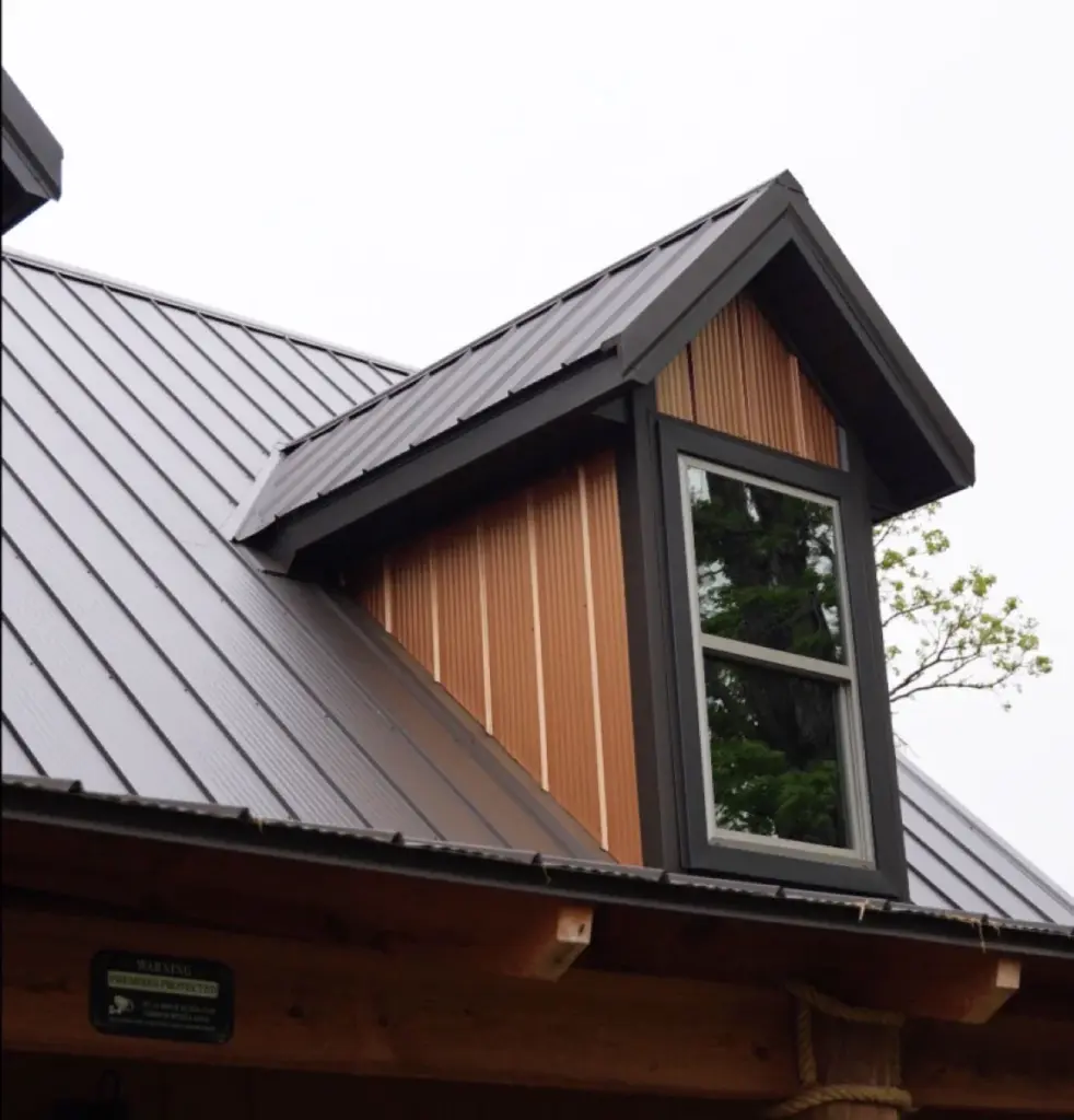 A close up view of a dark grey metal roof with signature wave metal panels from signature steel.