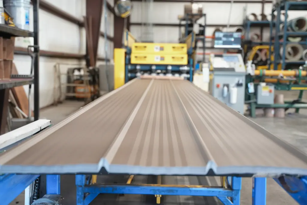 metal roofing panels coming out of a metal roller at the signature steel shop