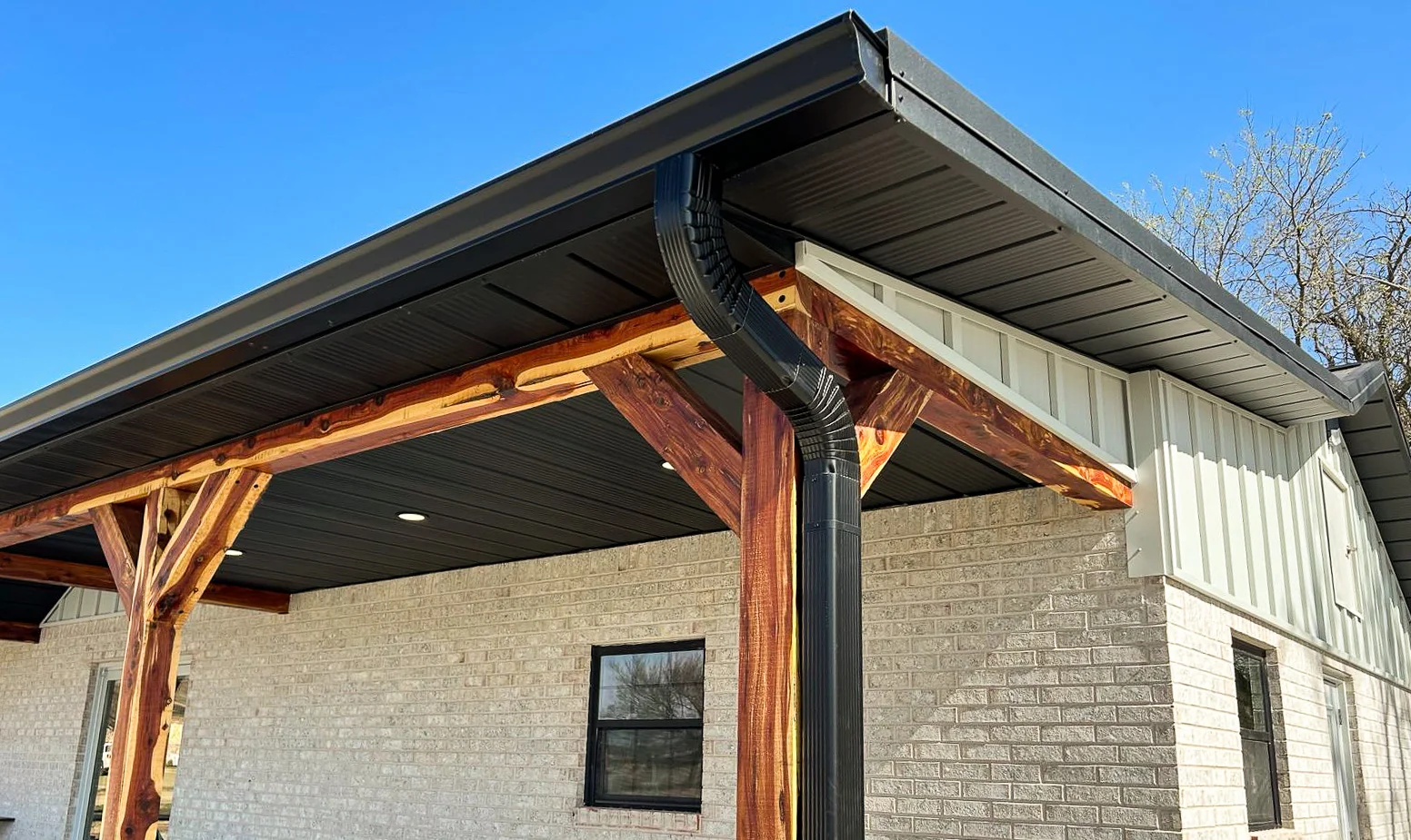 black standing seam metal roof in fayetteville arkansas with a rock chimney